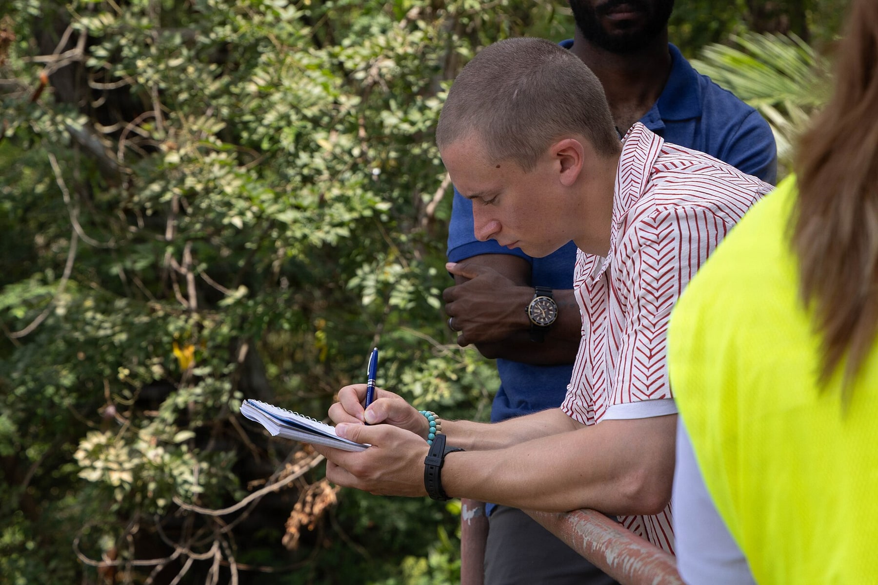 A water-quality specialist records field observations in a notebook.