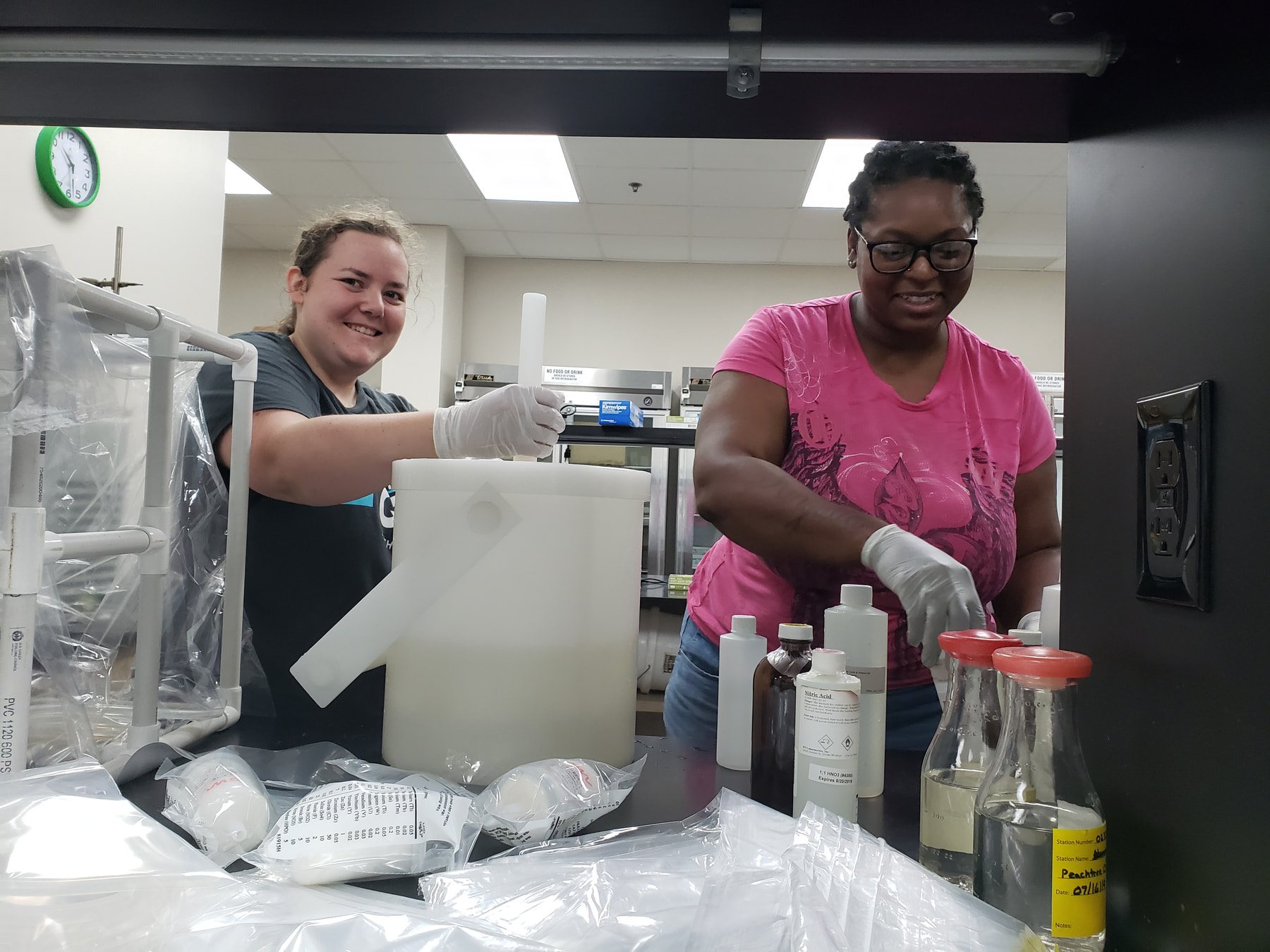 Two hydrologic technicians prepare water samples for laboratory analysis.