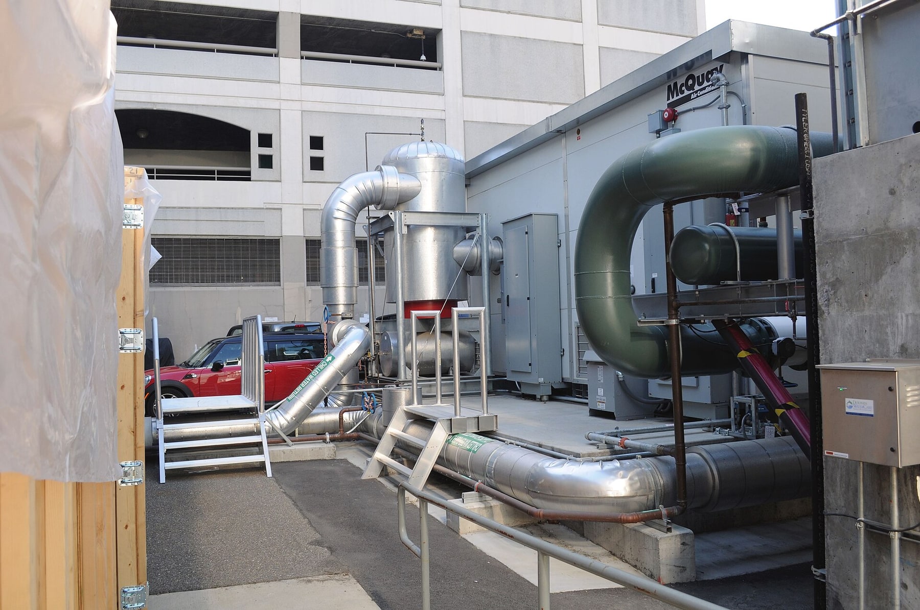 Large chilled-water supply and return pipes connect outdoor data-center cooling equipment.